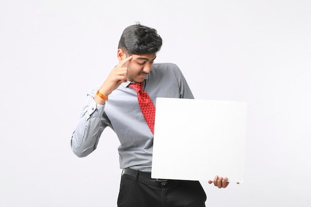 Young Indian business executive showing blank sign board over white background.