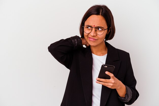 頭の後ろに触れて、考えて、選択をする孤立した電話を持っている若いインドのビジネスウーマン。