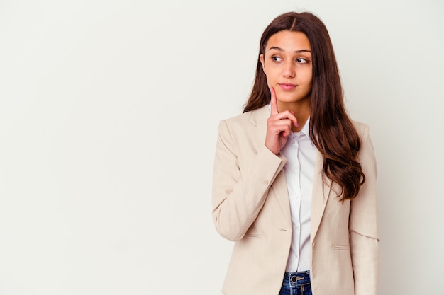 Young Indian business woman isolated on white looking sideways with doubtful and skeptical expression.