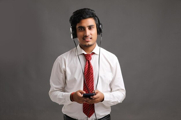 Young indian businessman or employee using smartphone.