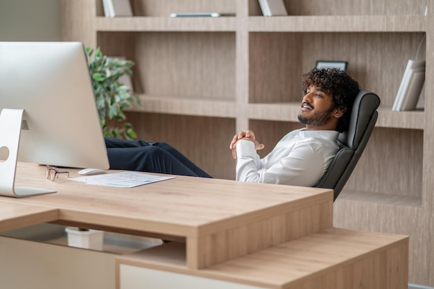 Young indian businessman sitting in the chair in the office