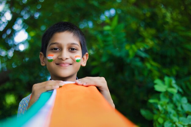 Young indian child with indian flag on face