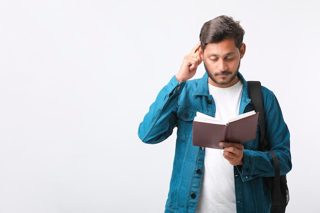 Young Indian college student holding diary in hand on white background.