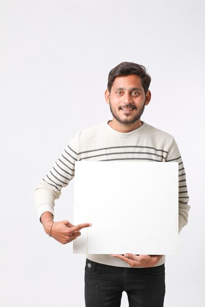 Young Indian college student showing blank signboard on white background.