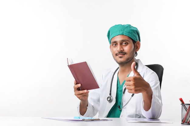 Young indian doctor reading diary at clinic