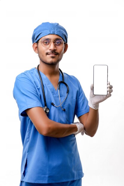 Young indian doctor showing smartphone screen over white background.