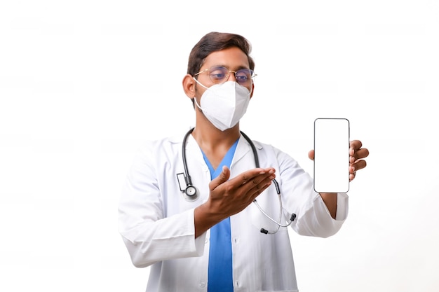 Young indian doctor showing smartphone screen over white background.