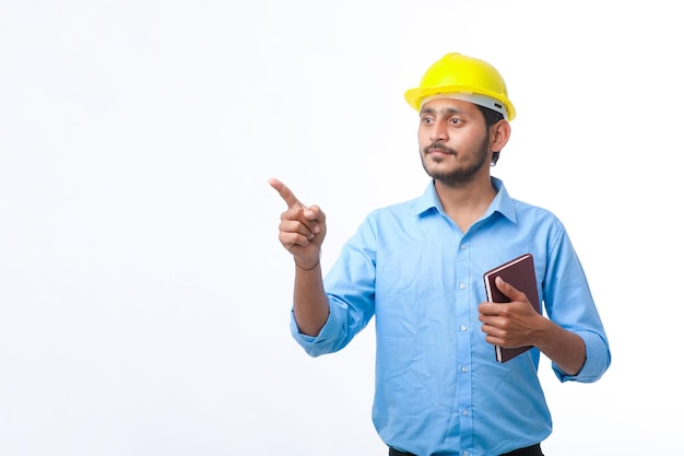 Young indian engineer or student wearing hardhat on white background.