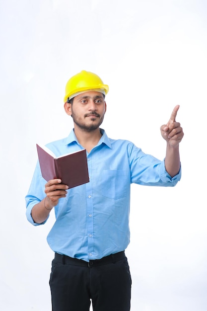 Young indian engineer wearing hardhat and watching diary