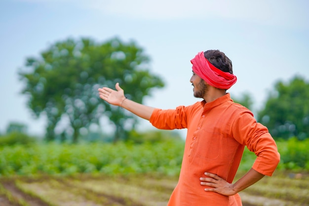 Young indian farmer at agriculture field.