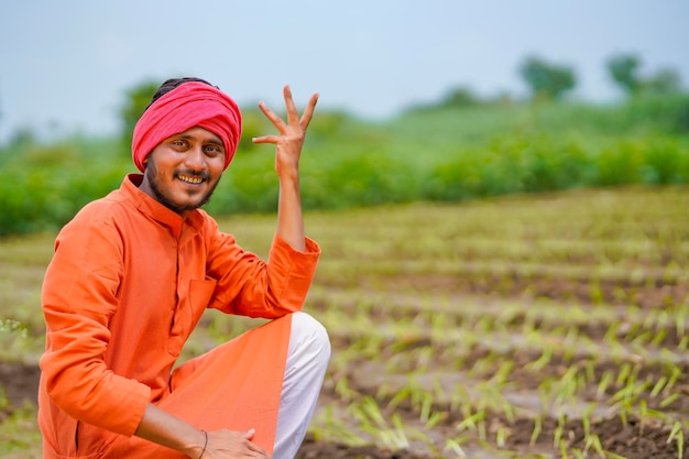 Photo young indian farmer at agriculture field.