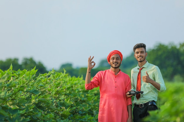 Giovane agricoltore indiano e agronomo che mostra colpi al campo agricolo
