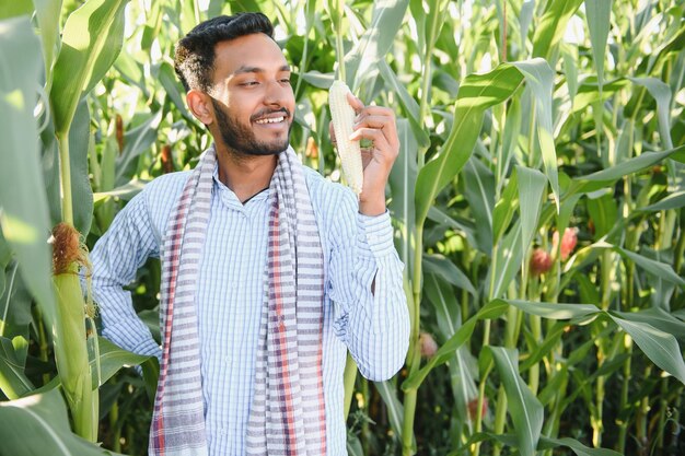 young indian farmer at corn field