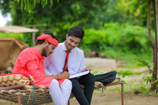 銀行家と話し合う若いインドの農夫