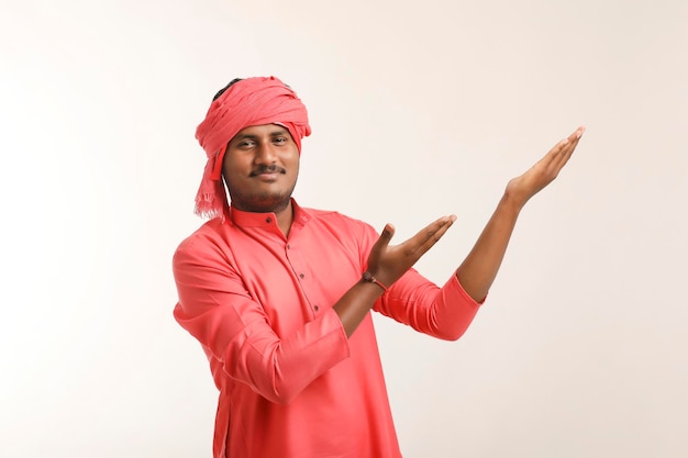 Young indian farmer giving expression on white background.