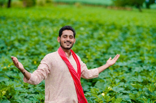 Young Indian farmer at green agriculture field.