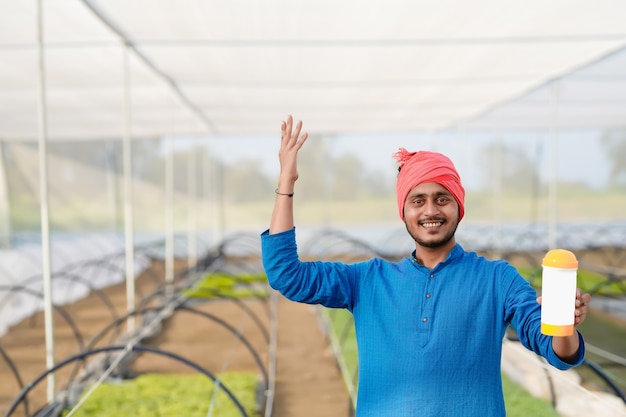 Young indian farmer at greenhouse or poly house