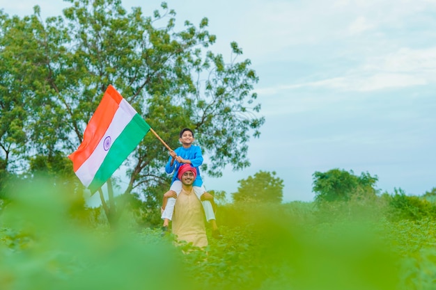 Young indian farmer and his child with indian flag