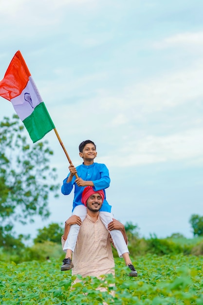 Young indian farmer and his child with indian flag