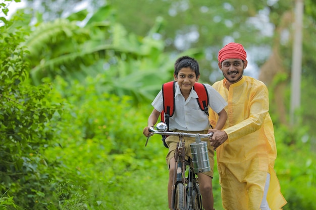 Young Indian farmer and his son going to school