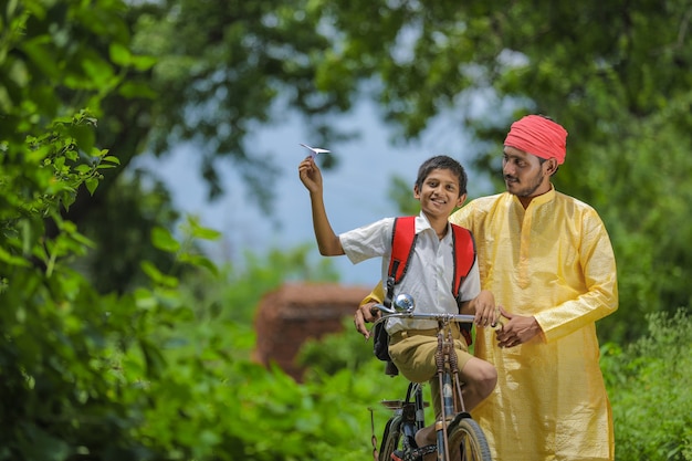 Young Indian farmer and his son going to school