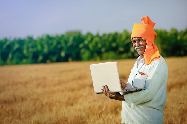 Молодой индийский фермер в своем пшеничном поле
