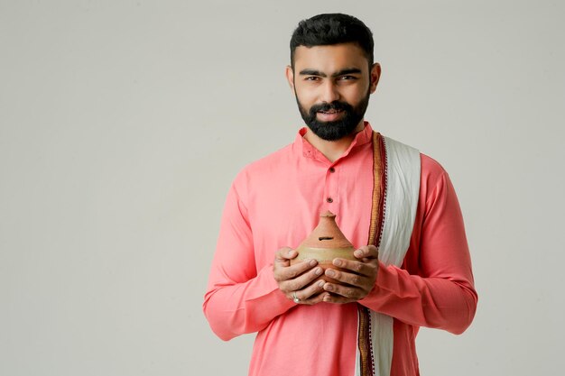 Photo young indian farmer holding piggy bank or gullak investment and banking concept