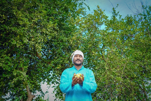 Young indian farmer at lemon field