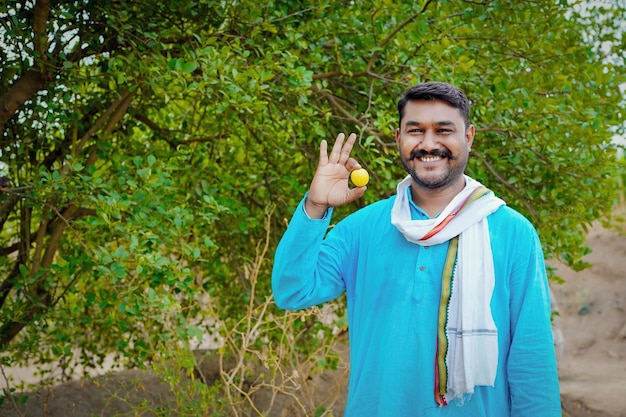 Young indian farmer at lemon field