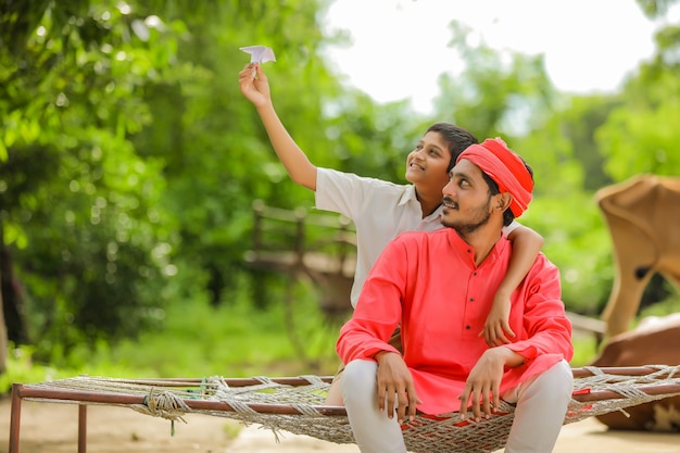 Young indian farmer playing with his son