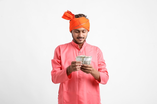 Young Indian farmer posing with currency