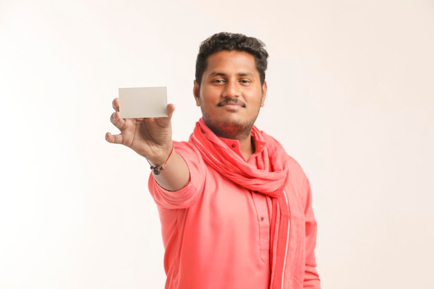 Young indian farmer showing card on white background.