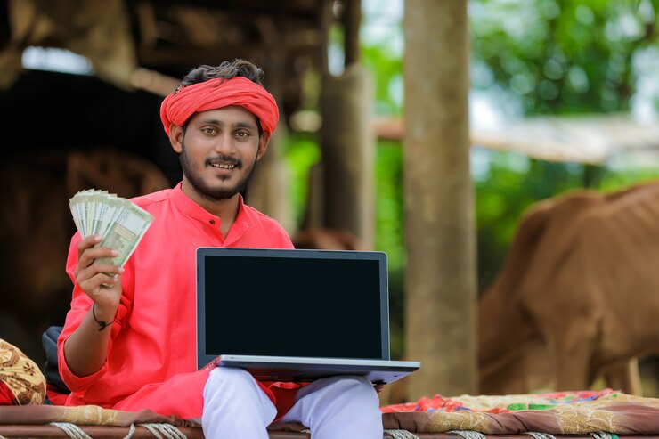 Photo young indian farmer showing a laptop