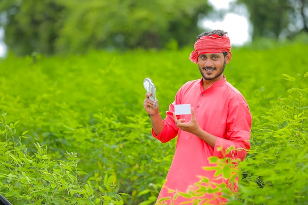 Young indian farmer showing money and a card