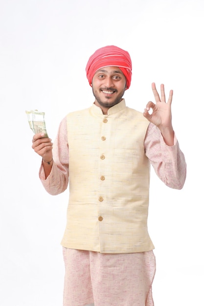 Young indian farmer showing money on white background.