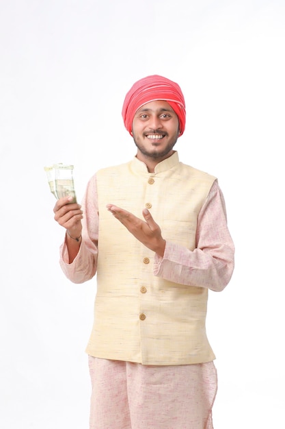 Young indian farmer showing money on white background.