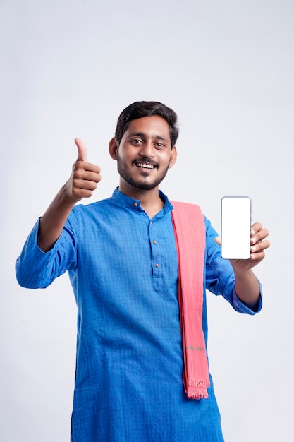 Young indian farmer showing smartphone and giving expression on white background.