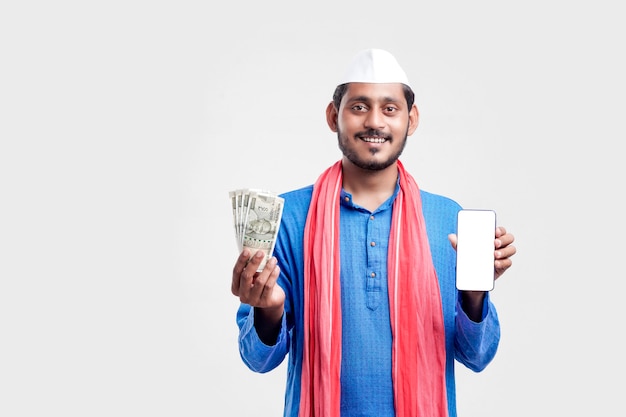 Young indian farmer showing smartphone and money on white background.