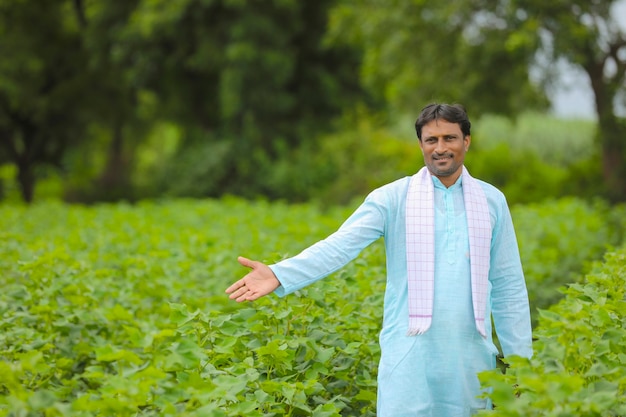 Молодой индийский фермер, стоящий в поле хлопкового сельского хозяйства.