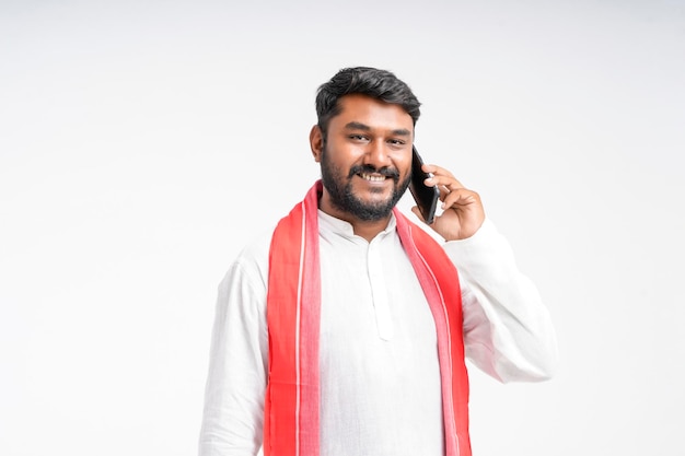 Young indian farmer talking on mobile phone over white background