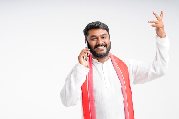 Young indian farmer talking on mobile phone over white background