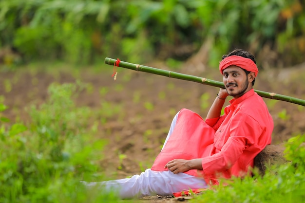 Young indian farmer in a traditional costume on the field