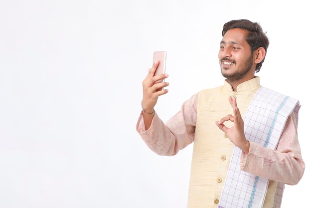 Young indian farmer using smartphone on white background.