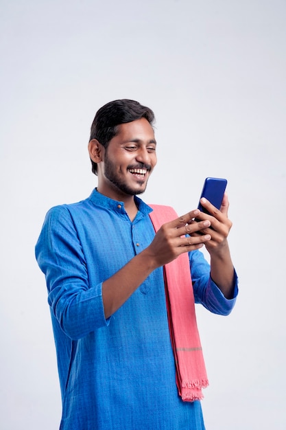 Young indian farmer using smartphone on white background.