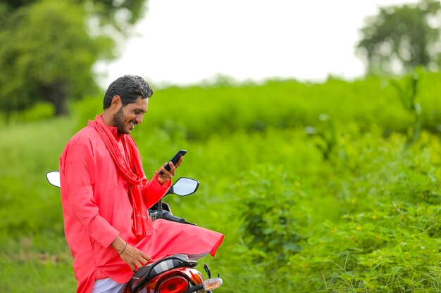 Young indian farmer using a smartphone