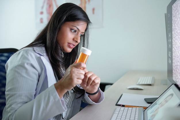 Young indian general practitioner video calling coworker and discussing new pills or supplements