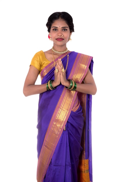 Young Indian girl in traditional clothing greeting namaste, Welcome, Indian girl in a tradition sari with welcome expression (inviting)