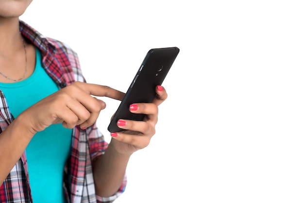 Young Indian girl using a mobile phone or smartphone isolated on a white background