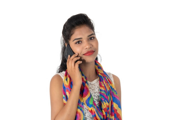 Young Indian girl using a mobile phone or smartphone isolated on white