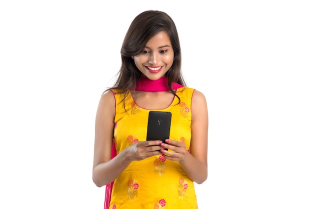 Young Indian girl using a mobile phone or smartphone isolated on a white